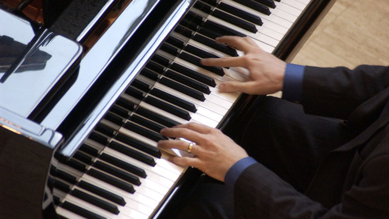 Photo of hands playing piano. 