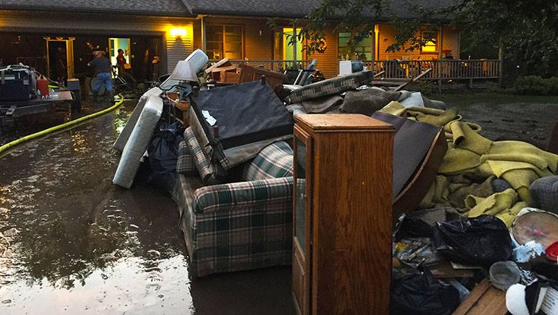 Colleagues and other volunteers helped clear waterlogged furniture and other items from the home of Lynn Luloff. 